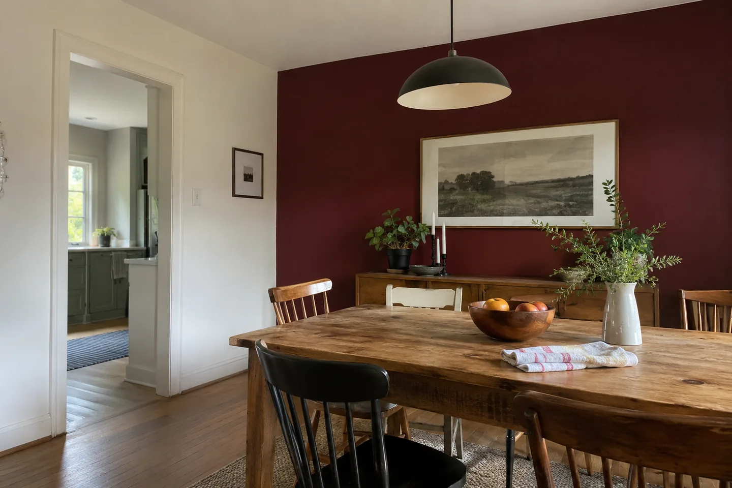 Burgundy dining-room accent wall with a simple timber table